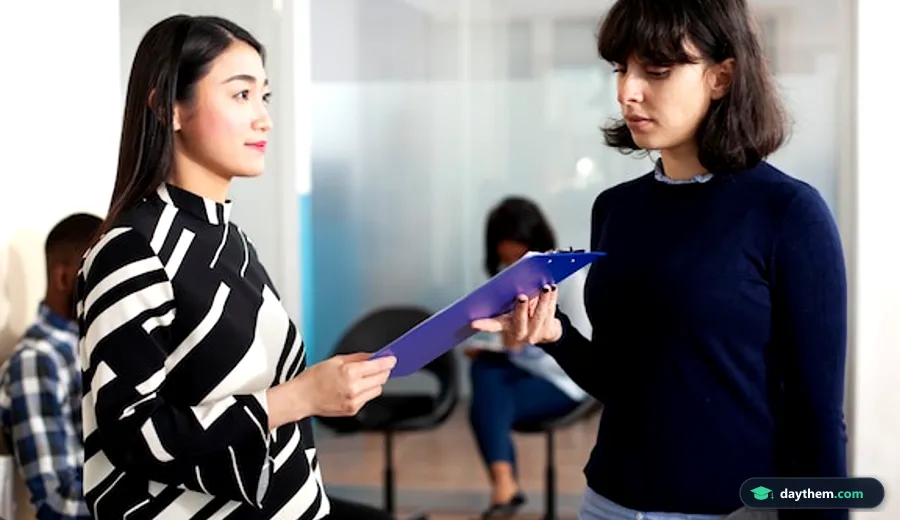 Ứng viên trao hồ sơ đăng ký dự thi cho quản lý tại bàn làm việc trong văn phòng.