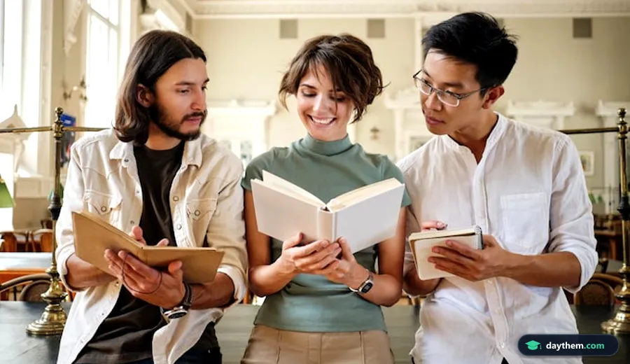 Nhóm sinh viên trẻ đang quây quần học tập, đọc sách và trao đổi tại bàn trong không gian thư viện đại học