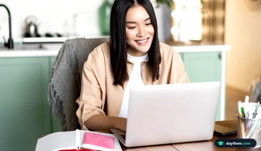 Nữ sinh đang học trực tuyến qua video call trên máy tính xách tay và mỉm cười trước màn hình