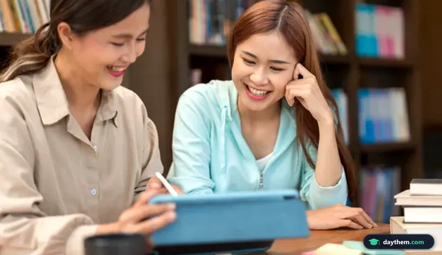 Gia sư đang chỉ bài học trên máy tính bảng cho học sinh