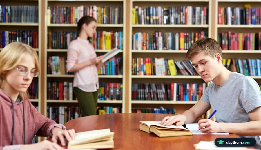 Học viên đối chiếu cấu trúc đề thi ngoại ngữ CEFR trong khi đang ngồi viết và ghi chú trên giấy tại bàn làm việc có sách vở xung quanh.